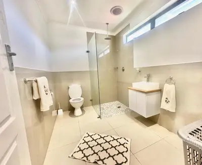 a bathroom with a shower toilet and a sink at Lalla Cottages - Cape Town in Cape Town