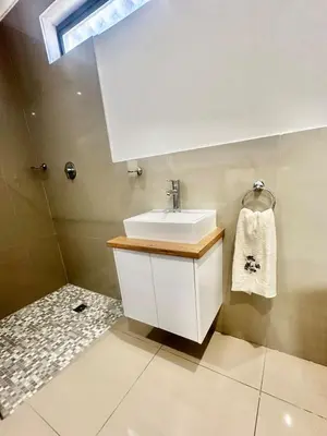 a bathroom with a white sink and a skylight at Lalla Cottages - Cape Town in Cape Town