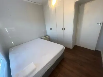 a bedroom with a white bed and white cabinets at triplediz in Blackheath