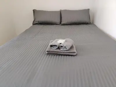 a bed with a blanket and towels on it at Kenwyn Micro Apartments 2 in Cape Town