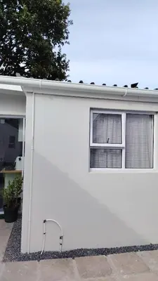 a white house with a window and a door at Kenwyn Micro Apartments 2 in Cape Town