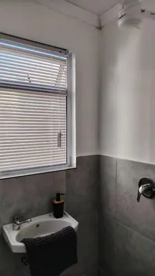 a bathroom with a sink and a window at Kenwyn Micro Apartments 2 in Cape Town