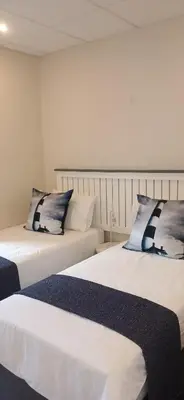 two beds sitting next to each other in a room at Salt & Cellar - Paarl - Self Catering Apartment in Paarl