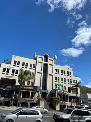 a white building with cars parked in front of it at Salt & Cellar - Paarl - Self Catering Apartment in Paarl
