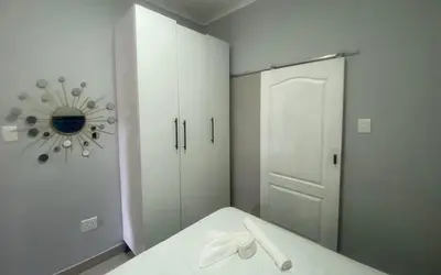 a room with a bed and a mirror and a closet at JM B&B - Mandalay in Mandalay