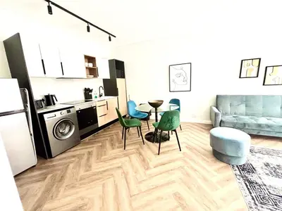 a kitchen and living room with a table and chairs at Modern Luxe On Park in Cape Town