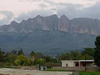 a house with a mountain in the background at Firehouse selfcatering Garden Cottage no 2 in Wellington