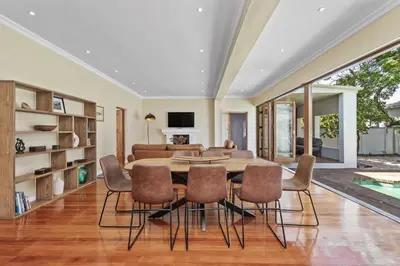 a dining room with a table and chairs at Spacious Claremont Home with Pool Fireplace in Cape Town