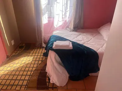 a small room with a bed and a window at home away in Bellville South