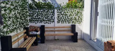a bench sitting on a patio next to a building at Oasis - Renovated - Queen extra length bed apartment in Cape Town