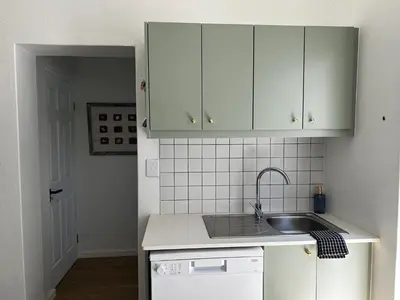 a kitchen with white cabinets and a sink at BEACHees - cute central cottage in Kleinmond