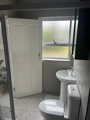 a bathroom with a toilet and a sink and a window at 16Park in Stikland