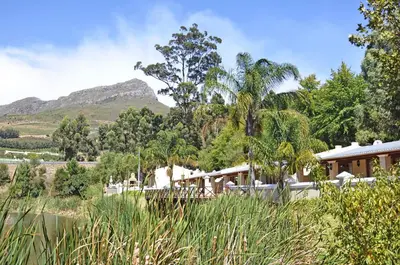 a house with a mountain in the background at Le Pommier Wine Estate in Stellenbosch