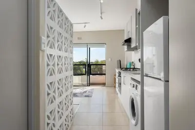 a kitchen with a white refrigerator and a tile floor at Breeze of the Sea Apartment in Cape Town
