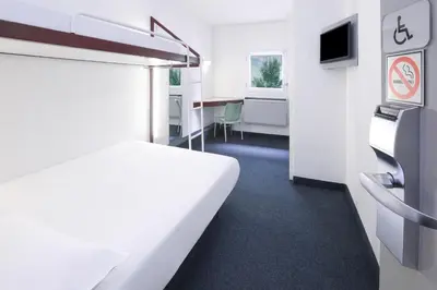 a white room with a bed and a desk at SUN1 Parow Cape Town in Avondale