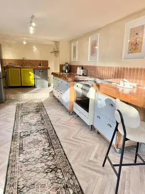 a kitchen with white appliances and a rug at Grande Casa - Central Stellenbosch in Stellenbosch