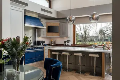 a kitchen with blue cabinets and a blue island at Franschhoek Homestead Manor House in Franschhoek