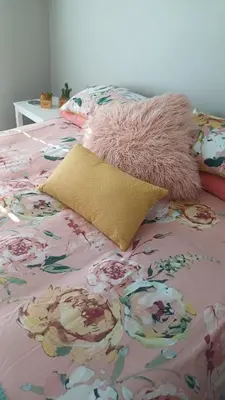 a bed with a pink blanket and a pillow on it at Sozo - our place at the ocean in Gordonʼs Bay