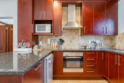a kitchen with wooden cabinets and a stove top oven at Holly Tree Franschhoek Accommodation in Franschhoek