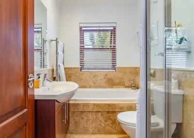 a bathroom with a tub and a sink and a toilet at Holly Tree Franschhoek Accommodation in Franschhoek
