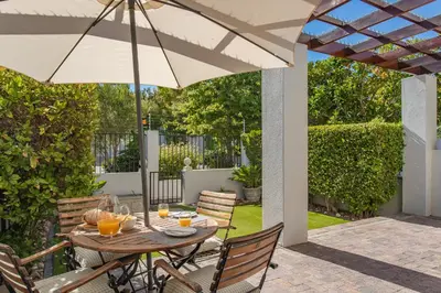 a table with an umbrella on a patio at Holly Tree Franschhoek Accommodation in Franschhoek