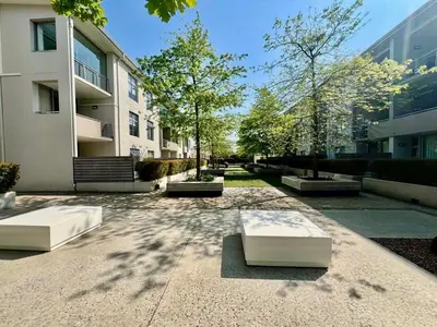 a courtyard with two benches in front of a building at Stay at Andringa Walk Luxury Apartment in Stellenbosch