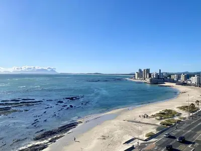 a view of a beach with buildings and the ocean at Pips Place 203 in Strand