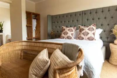a bedroom with a large bed with a large headboard at Little Villa by Ideas Cartel in Hermanus