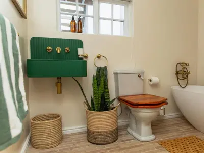 a bathroom with a toilet and a plant at Little Villa by Ideas Cartel in Hermanus