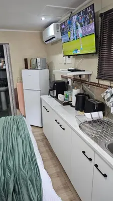 a kitchen with white cabinets and a white refrigerator at Victoria's Rest in Windsor Park
