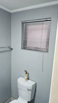 a bathroom with a white toilet and a window at Victoria's Rest in Windsor Park