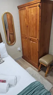 a bedroom with a bed and a mirror and a chair at Victoria's Rest in Windsor Park