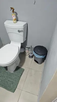 a bathroom with a toilet and a trash can at Victoria's Rest in Windsor Park