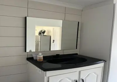 a bathroom with a black sink and a mirror at Modern Studio with Pool, 5 mins from Beach in Cape Town