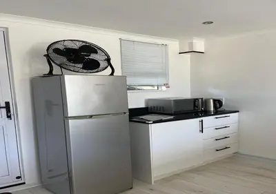 a kitchen with a refrigerator and a microwave at Modern Studio with Pool, 5 mins from Beach in Cape Town