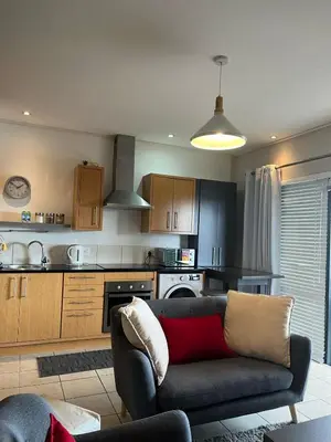 a living room with a couch and a kitchen at Century City Studio with Table Mountain Views in Cape Town