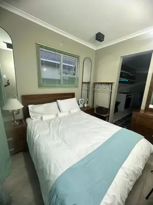 a bedroom with a large bed and two mirrors at 29Windsor in Silver Sands