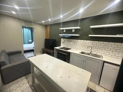 a kitchen with a sink and a couch in a room at 29Windsor in Silver Sands