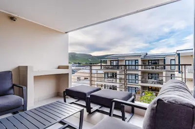 a balcony with a view of a building at Oceanfront Escape with mountain views in Hermanus