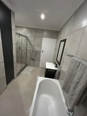 a bathroom with a tub and a shower and a sink at The Peaceful Nook Somerset 2 in Somerset West