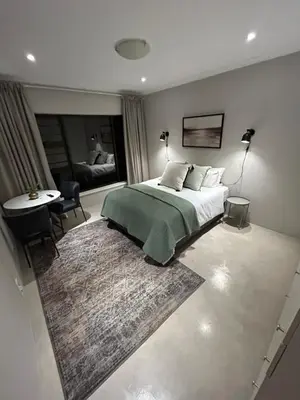 a bedroom with a bed and a table and a bed and a room at The Peaceful Nook Somerset 2 in Somerset West