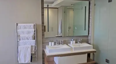 a bathroom with two sinks and a large mirror at Luxury Penthouse -Crystal Towers in Cape Town