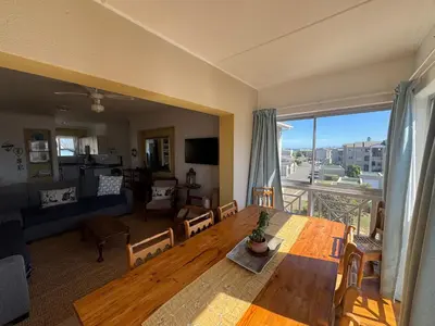 a living room with a table and a couch at Greenways Getaway in Gordonʼs Bay