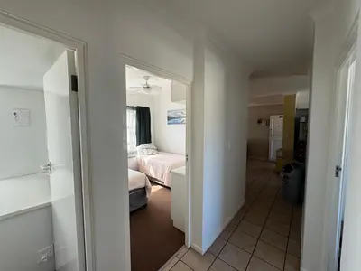 a room with a bedroom with a bed and a mirror at Greenways Getaway in Gordonʼs Bay