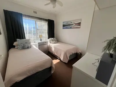 a small room with two beds and a window at Greenways Getaway in Gordonʼs Bay