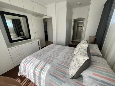 a small bedroom with a bed and a mirror at Greenways Getaway in Gordonʼs Bay
