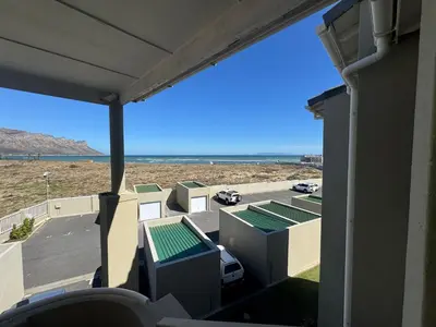 a view of the beach from the balcony of a house at Greenways Getaway in Gordonʼs Bay