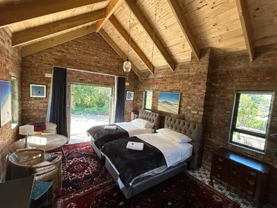 a bedroom with two beds in a brick wall at Garden Studio in Greyton
