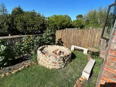 a garden with a fire pit in the grass at Garden Studio in Greyton