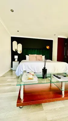 a bedroom with a bed and a glass table with a plate on it at Hideaway Haven 2 in Cape Town